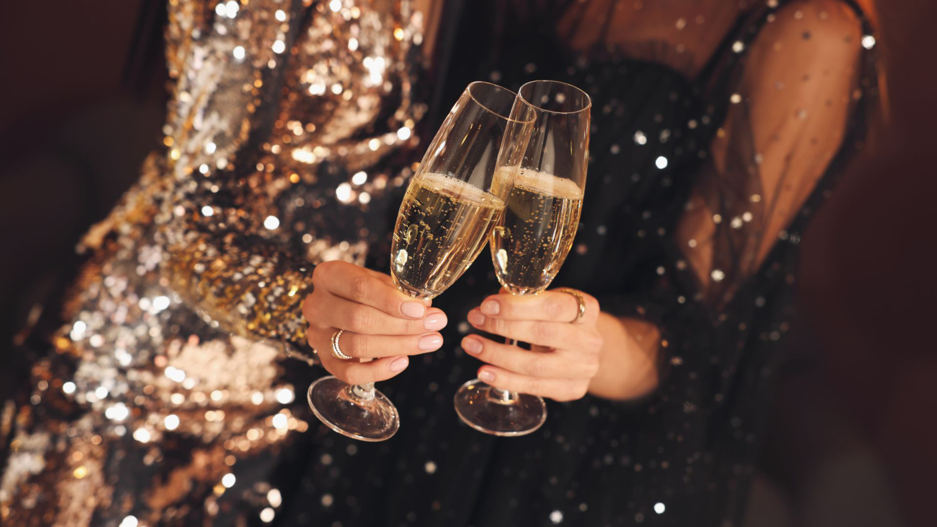 two female hands holding champagne glasses